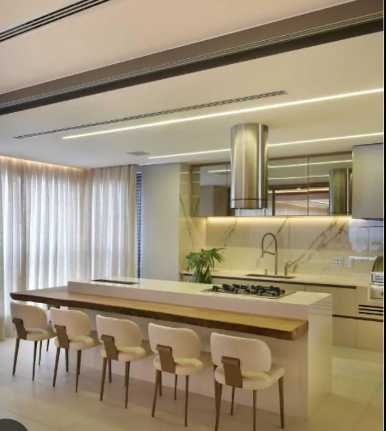 Cozinha branca em U com bancada clara e iluminação embutida